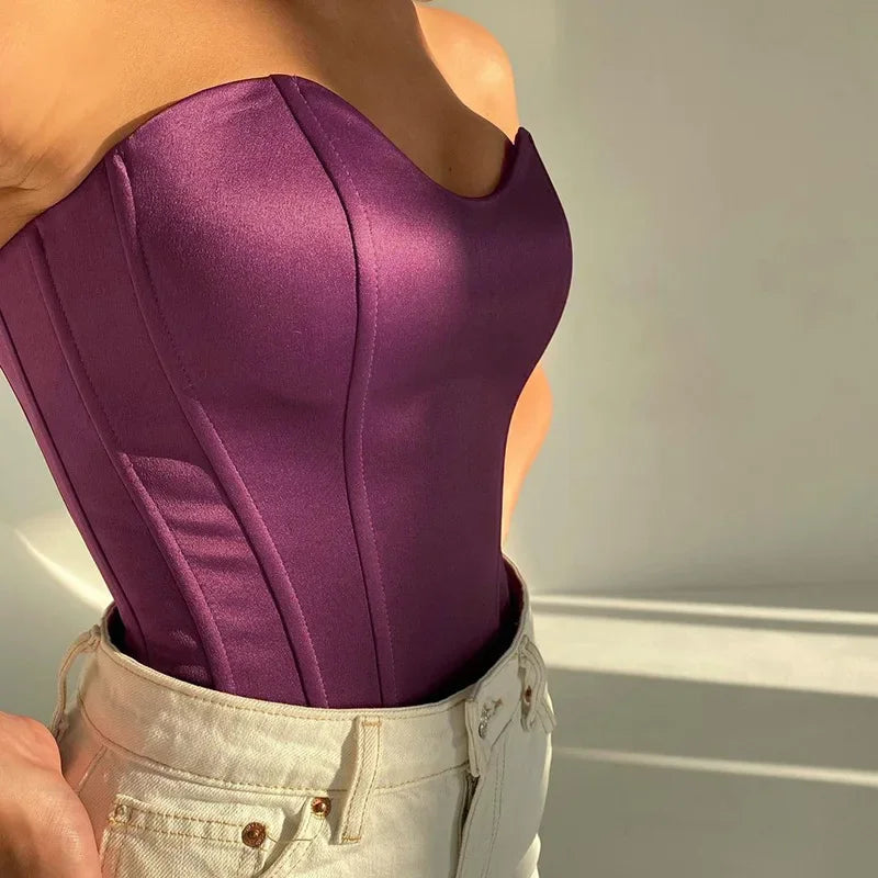 Purple satin corset top with structured seams paired with white denim jeans
